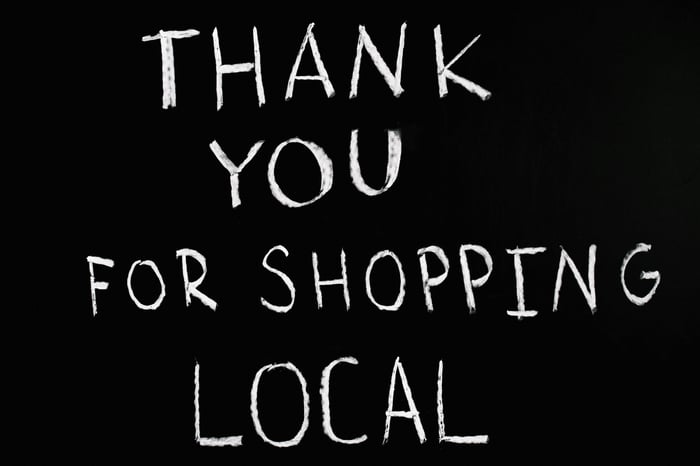 A chalkboard with handwritten message thanking for supporting local businesses.